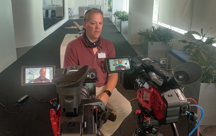 Videographer Shawn Chadwick checks the lighting and camera angles for the shoot, Cyber Security Video Production