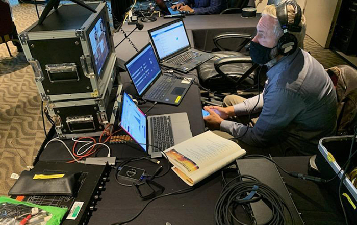 MTI's John Bogley monitors three laptops to keep the program both live and streaming.