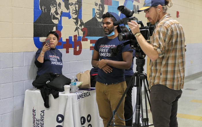 Director of Videography Ian Sbacio sets up the shot at the Kelly Miller Middle School. (Photo by Ashley Tillery.)