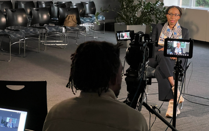 Vera Songwe waits for questions from the client a world away, with her son in the foreground to repeat them for her.