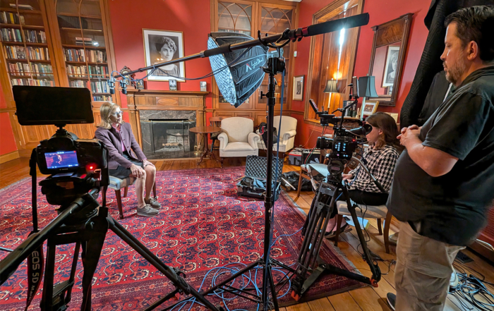Director of Photography Jamie Sides (r) monitors the recording of the interview.