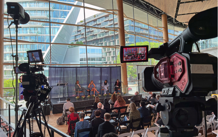 Two cameras focus on the speakers at the event. A third, stationary, camera also captured the event.