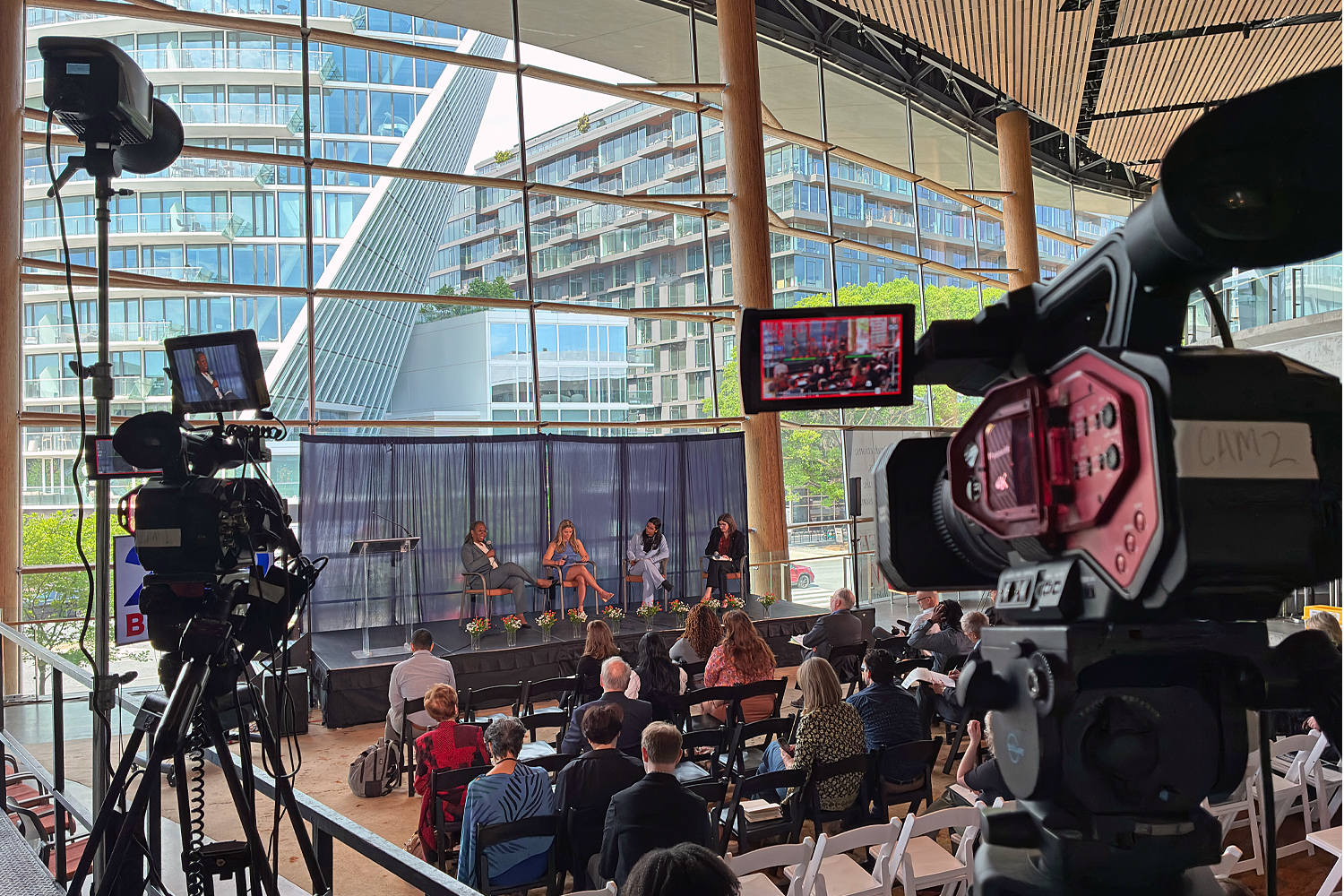 Two cameras focus on the speakers at the event. A third, stationary, camera also captured the event.